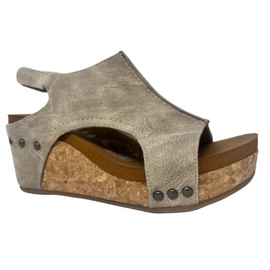 Side view of a single Liberty Wedge Sandal in Cream from the brand VERY G, featuring a metallic gray color, cork heel, and velcro strap.