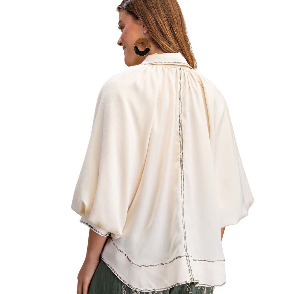 A woman stands with her back turned, wearing the FASHION GO Satin Balloon Sleeve Button Down Blouse featuring a wavy hem and stitch detail.