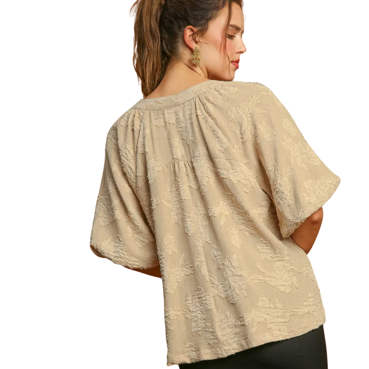 A woman with her hair tied back faces away, wearing the Umgee Textured Floral Puff Sleeve Blouse in beige, set against a white background.
