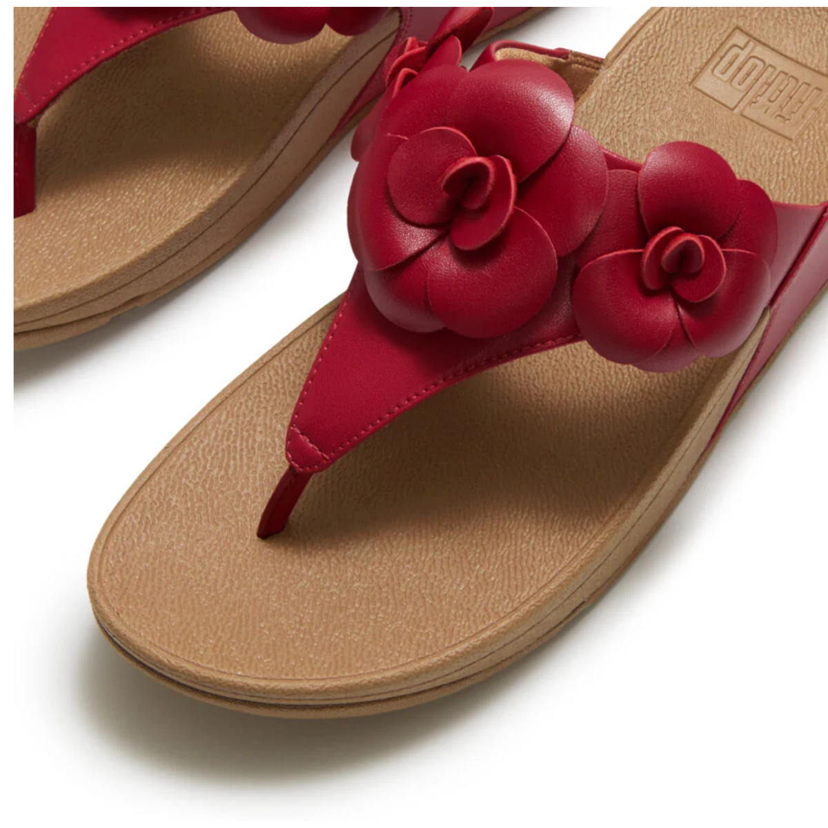 Close-up of Lulu Flower Flip Flop by FITFLOP USA LLC, tan toe-post sandals featuring red floral embellishments on the straps, designed for stylish comfort and arch support.