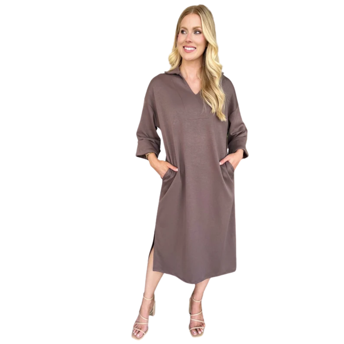 A woman in the Carole Christian Scuba Fabric Dress, a loose-fitting, midi-length style with three-quarter sleeves and side pockets, made in the USA, paired with strappy heeled sandals.
