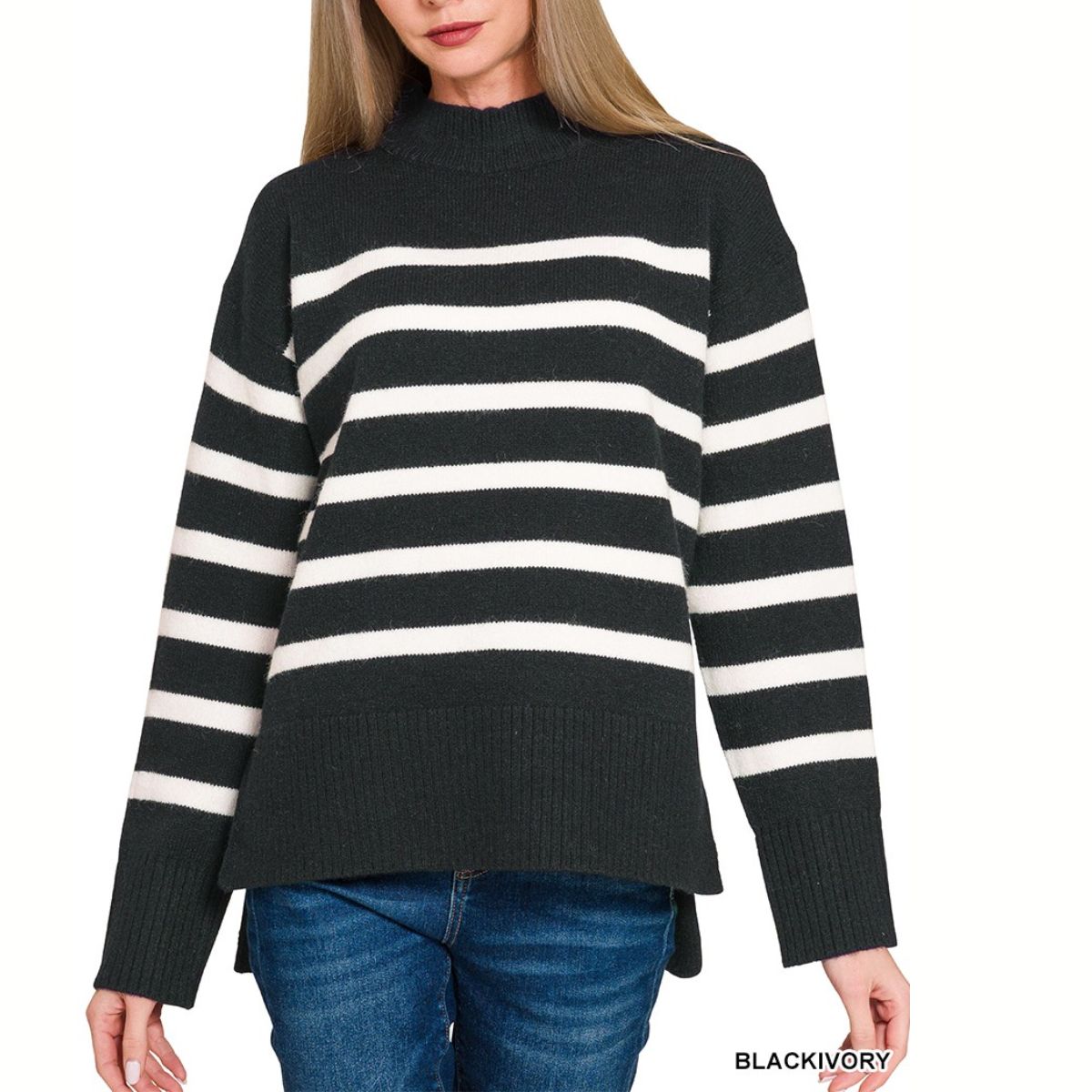 A woman wears the FASHION GO Striped Mock Neck Sweater with black and ivory stripes and blue jeans, highlighting a cozy knit style ideal for casual outings.