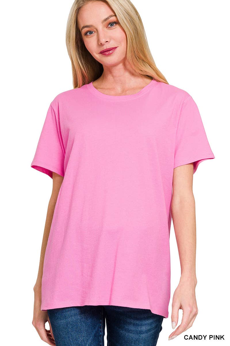 A woman wearing a loose-fitting 42POPS Short Sleeve Basic Tee in pink with blue jeans stands against a white background.