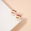 Lilla Haven's Santa Claus Stud Earrings | Red Rhinestone Christmas Earrings are displayed on a white and beige surface, making them the perfect festive addition to your holiday jewelry collection.
