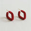 A pair of Retro Geometric Drop Earrings with a bold design from Ellemadera are displayed on a white background.