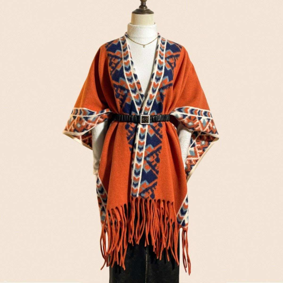 A mannequin showcases the ACCITY Vintage Plaid Tassel Shawl Women Winter Cape, featuring a belted waist and stylish tassels, layered over a white turtleneck.