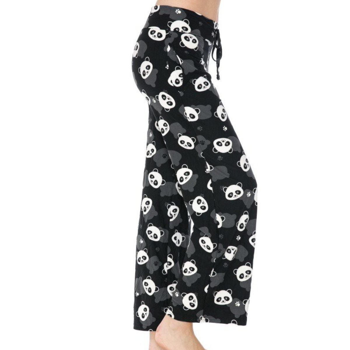 Dressed in FASHION GO's buttery soft pajama pants featuring a playful white panda print and an elastic waistband, a person stands barefoot, savoring the ultimate comfort.