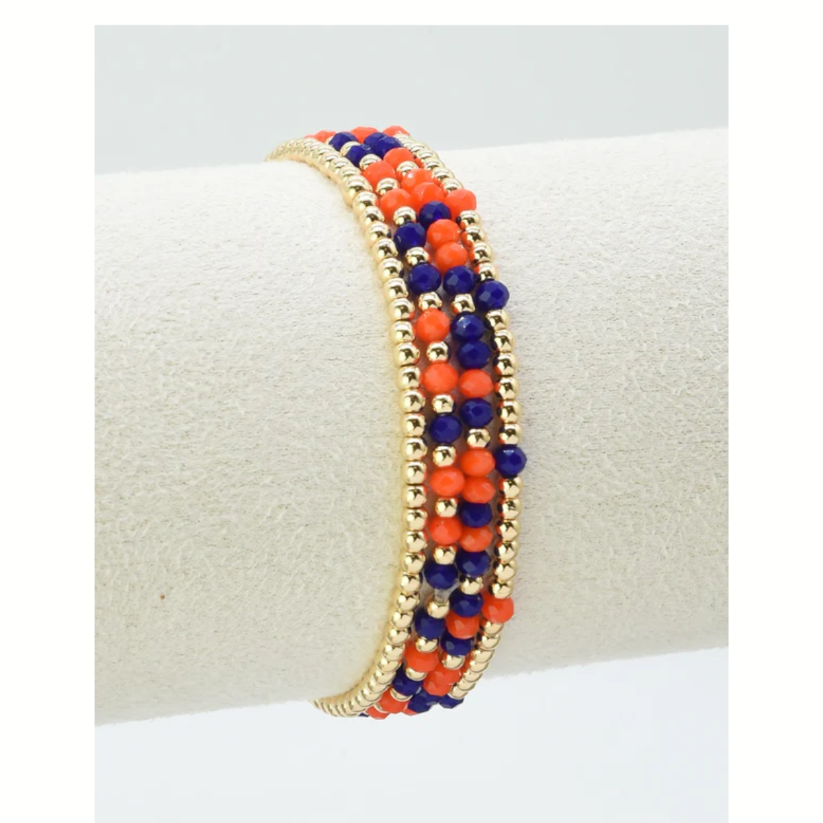 FASHION GO Set of 4 Glass Bead and Gold Stretch Bracelets—perfect for gameday—features gold, orange, and dark blue beads to show off your team colors, displayed on a white cylindrical stand.