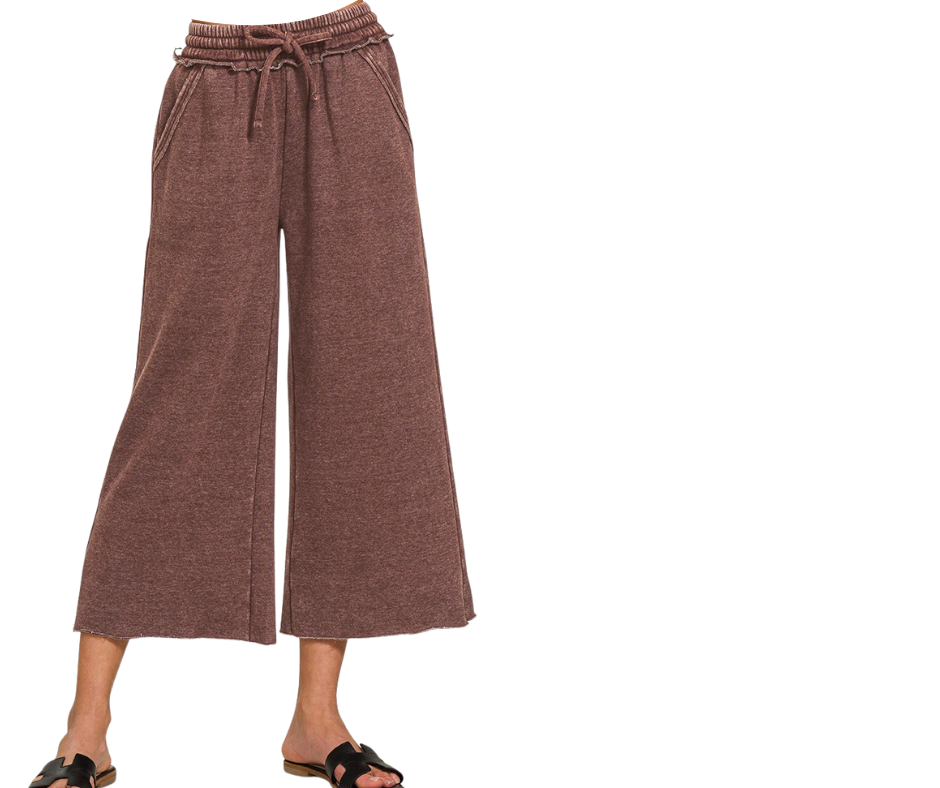 A person wearing Zenana Acid Washed Fleece Palazzo Sweatpants, featuring wide legs and a high-rise elastic waistband with drawstring, stands in black sandals against a white background.