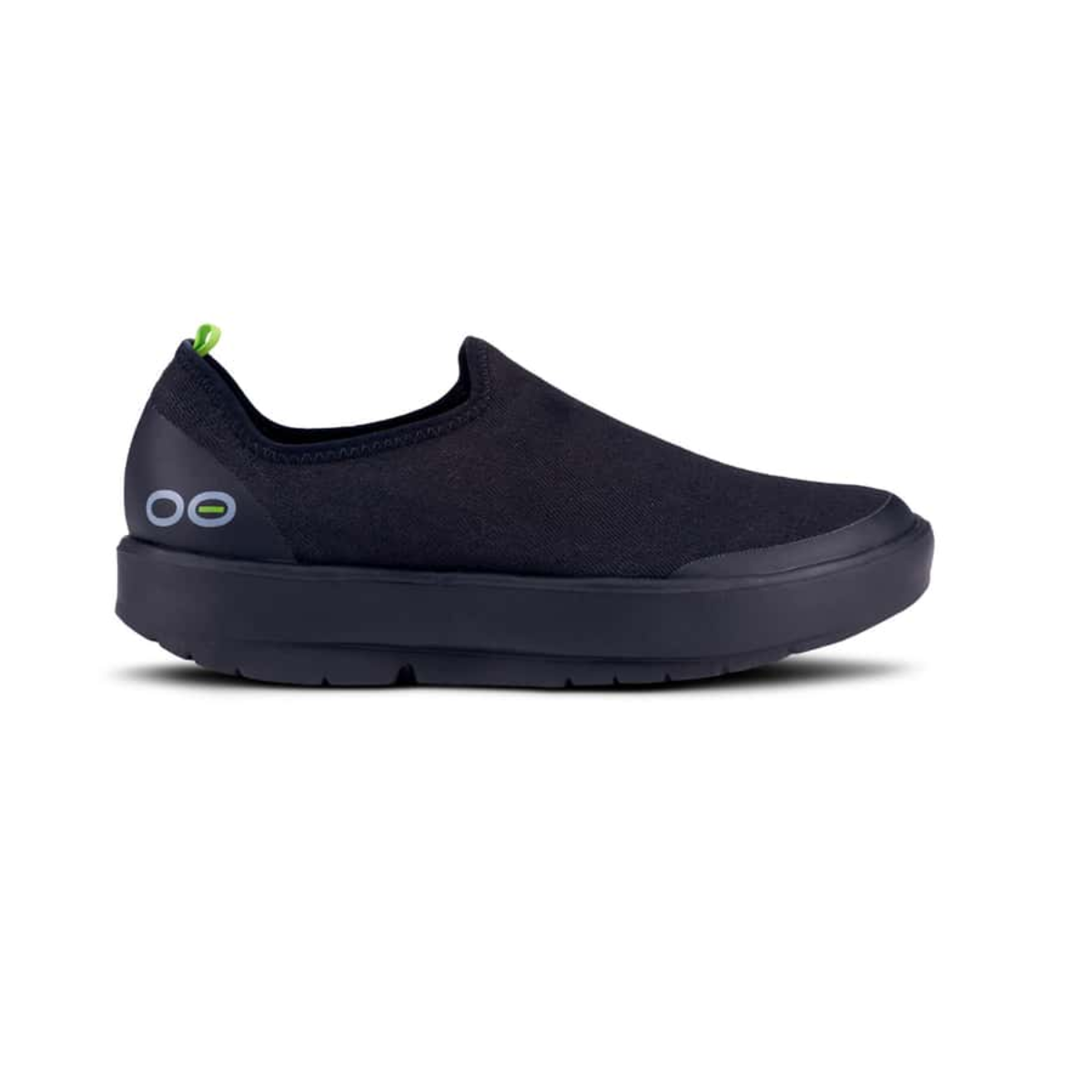 The OOFOS LLC Omg Eezee Women's Canvas Shoe Black Black features a sleek slip-on design with OOfoam construction for a thick, cushioned sole and two small circular designs near the heel for added style.