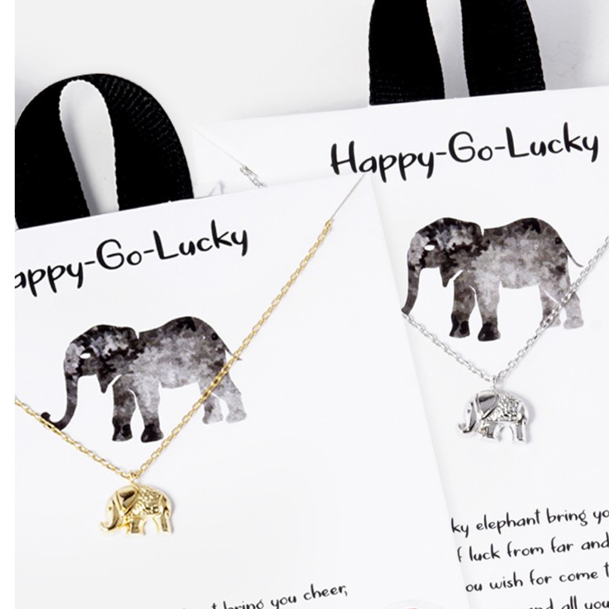 Two "Tiny Elephant Pendant" necklaces from the SPECIAL EFFECTS brand, one in gold and one in silver. Each necklace features a delicate elephant pendant and comes on a white card adorned with an elephant illustration and text. Each piece includes a 16" chain that adds a touch of elegance to any outfit.