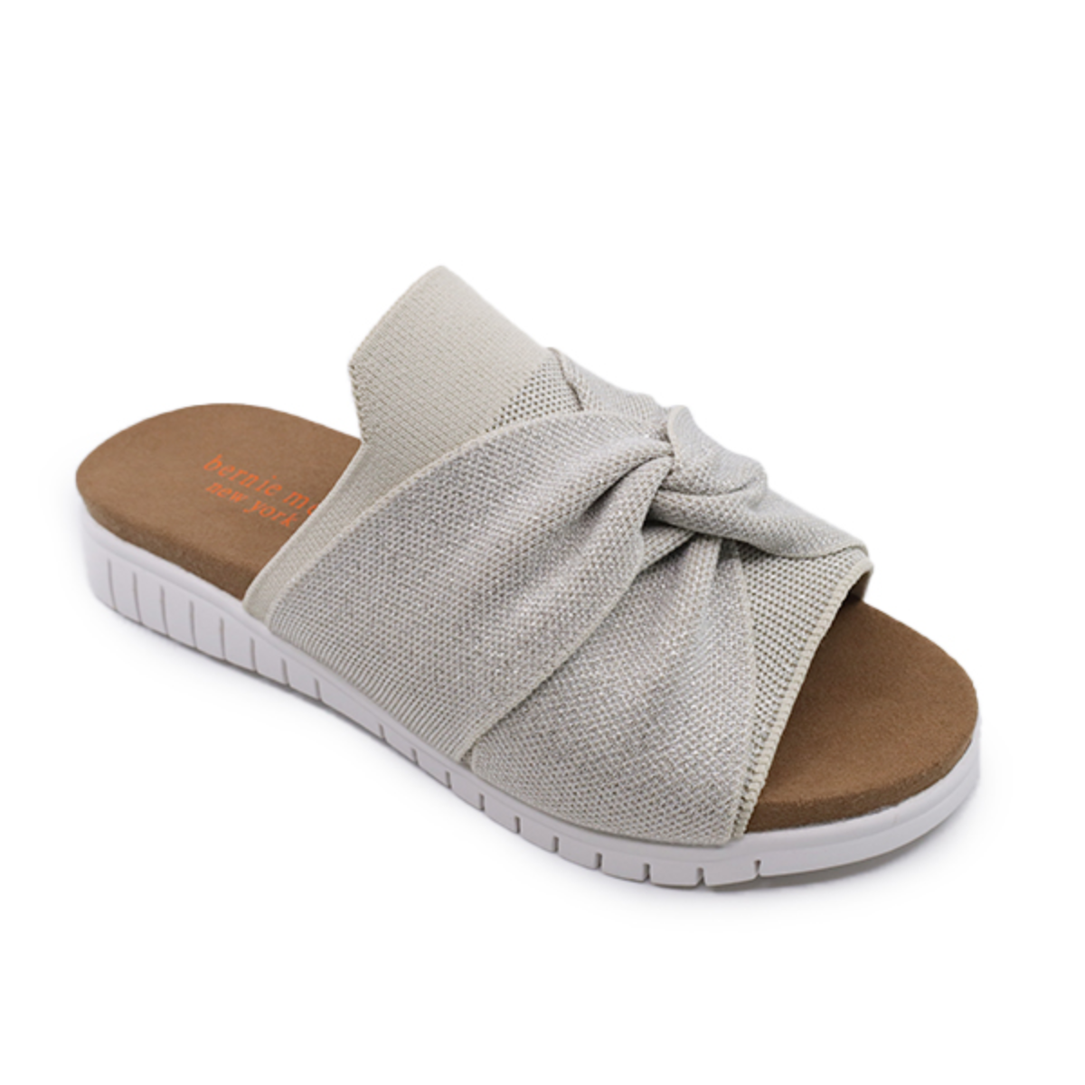The BERNIE MEV FREESIA NUDE SILVER, a beige slip-on sandal by BERNIE MEV, features a twisted fabric design on the upper, a white rubber sole, and a tan footbed.