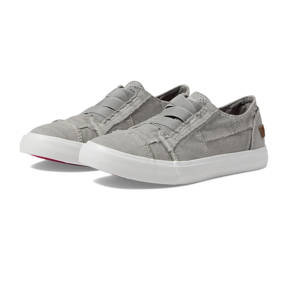 The Kids Marley Sneaker in Sweet Grey by BLOWFISH are gray slip-on casual shoes. They feature white rubber soles, elastic bands on top, and a small brown tag on the side.