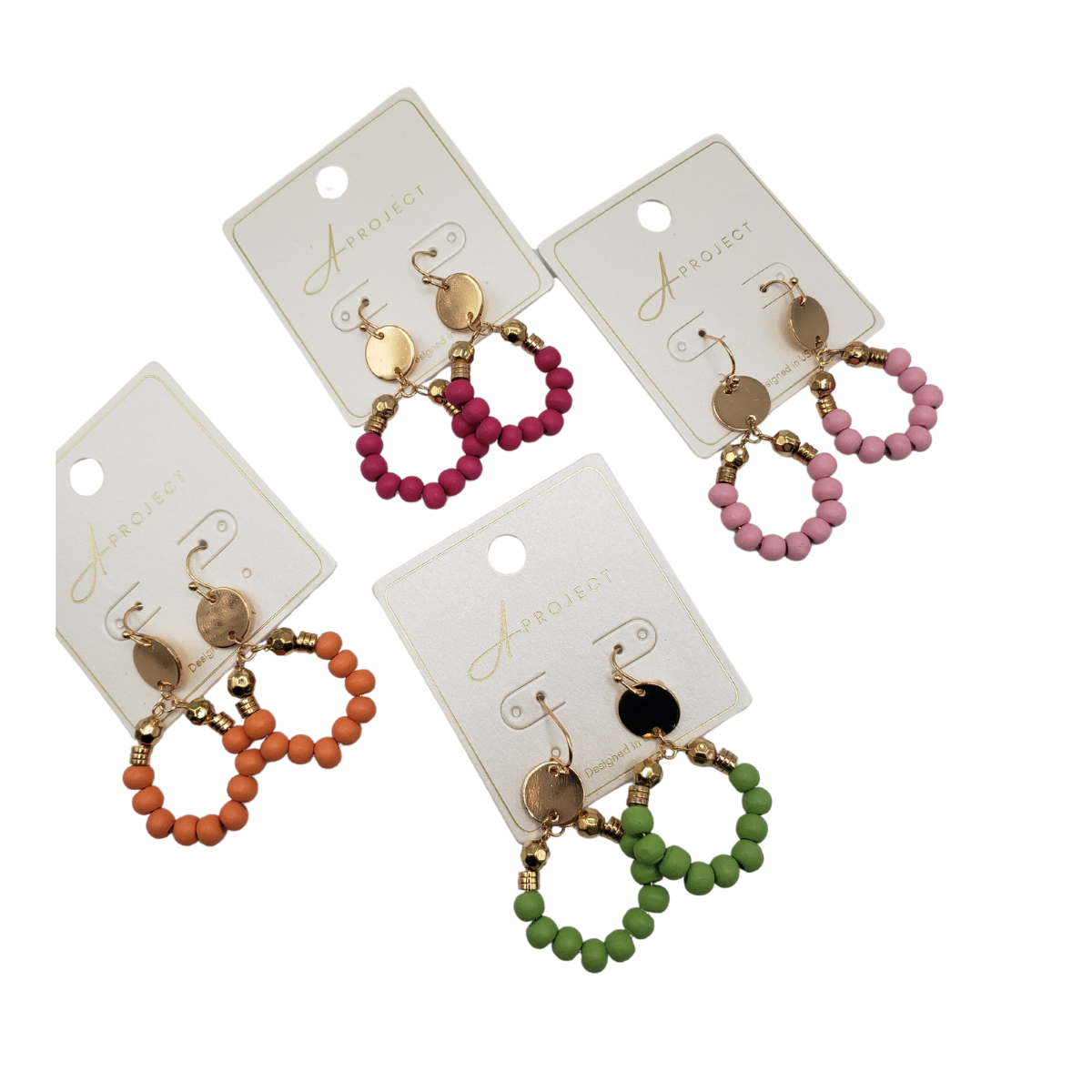 Four pairs of lightweight hoop earrings from SPECIAL EFFECTS, featuring pink, green, red, and orange bead designs, are displayed on labeled hanging cards. Product: Colored Bead Small Hoop Earrings.