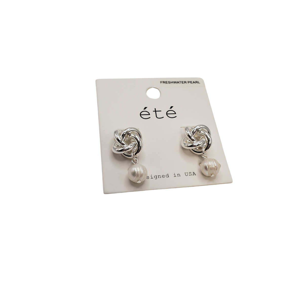 Dangle stud earrings featuring a love knot and freshwater pearls from SPECIAL EFFECTS come on an 'été' labeled white card.