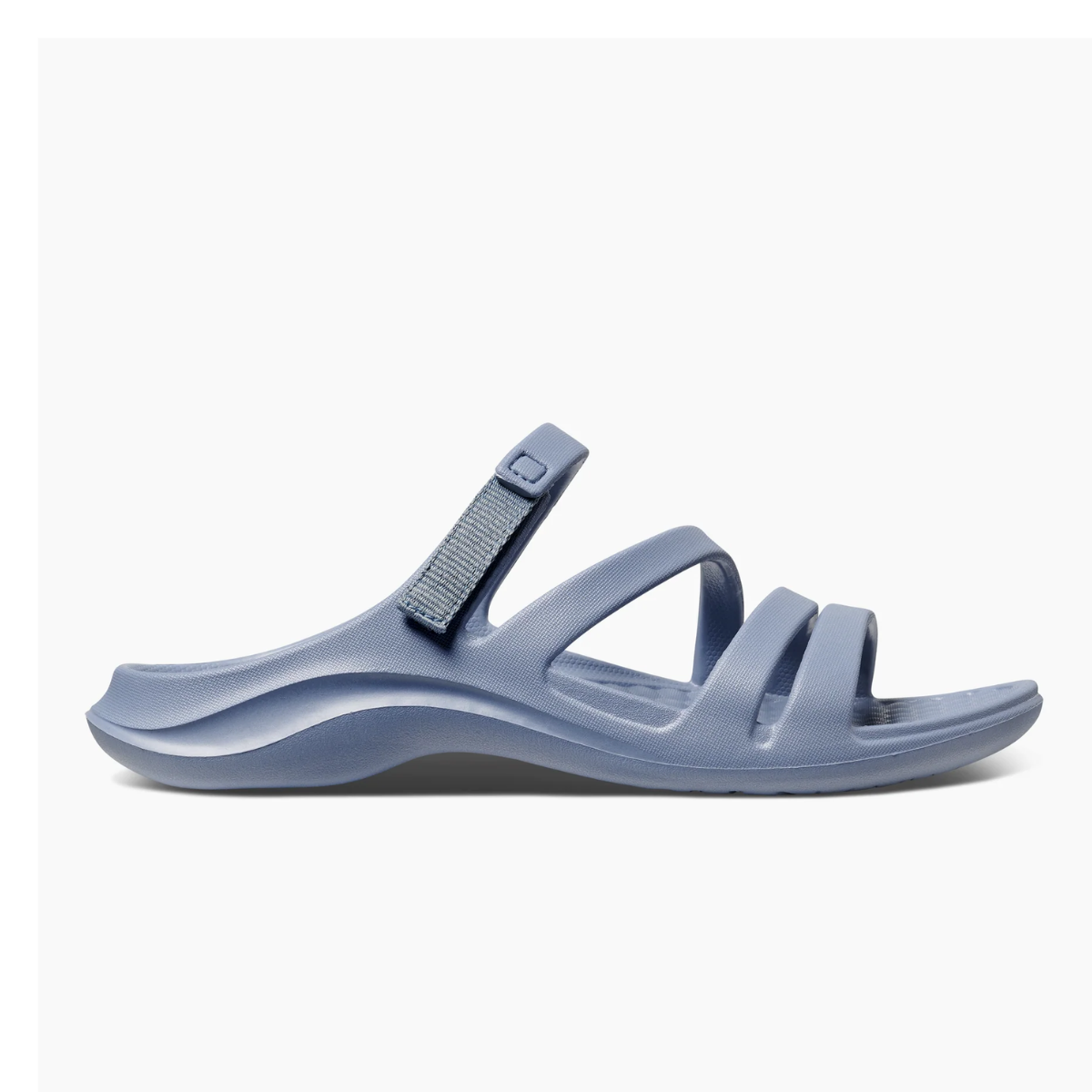 The Lakeshore Sandal in Ocean Tide by JOYBEES is a lightweight blue slide featuring a textured sole and back strap, set against a plain background.