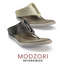 The Iris #1 Reversible Wedge Sandal by Flipflops & Whatnots features a textured strap and metal accent, crafted from vegan leather. With gold to pewter reversible technology, "Modzori Reversibles" proudly showcases its innovative design.