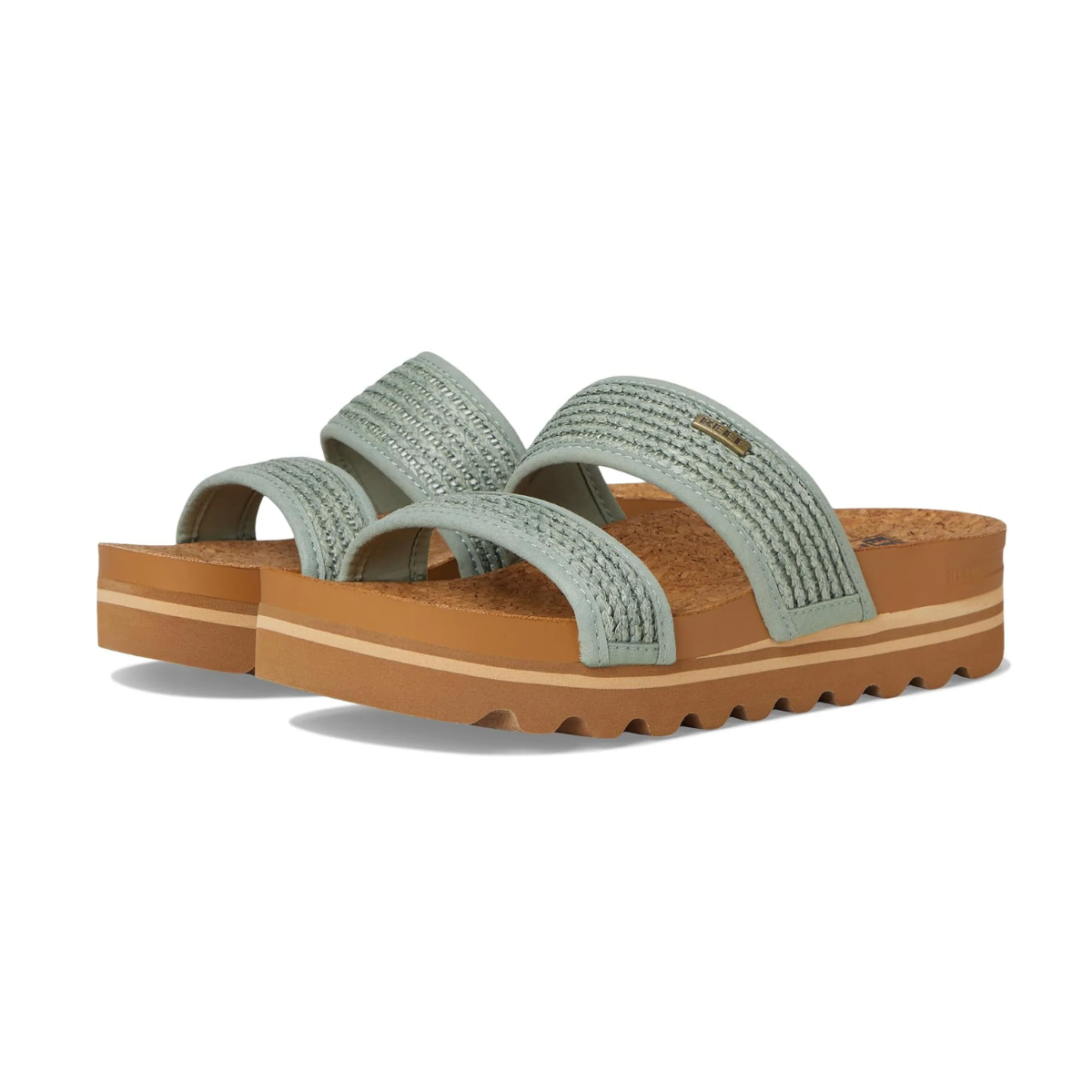 The REEF Cushion Vista Hi in Frosty Raffia features light green textured slide sandals with dual wide straps made of vegan leather, set on a brown cork and rubber sole with a wavy tread, combining style and eco-friendliness.