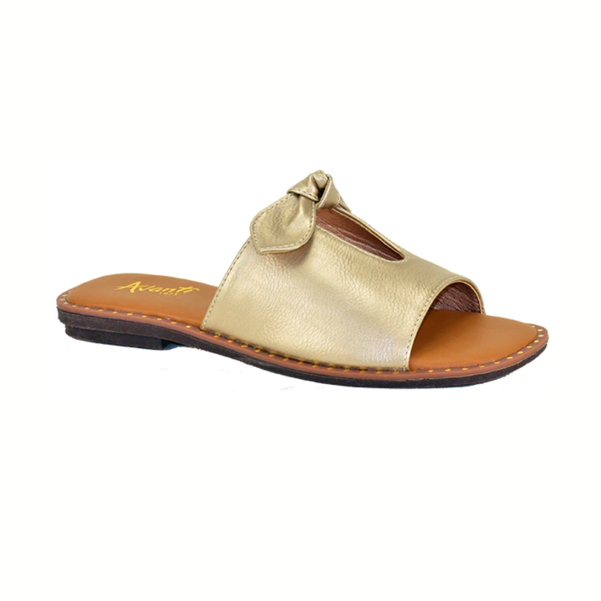 The Avanti Luvlee Slide Sandal in Soft Gold features an open toe, a charming bow on the upper strap, a flat sole, and a brown footbed. Available in whole sizes.