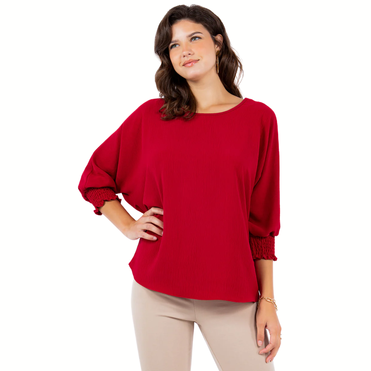 A woman models the LTX Air Flow Tops with Smocking Cuffs in red, featuring loose dolman sleeves and three-quarter length, paired with beige pants, against a white background.
