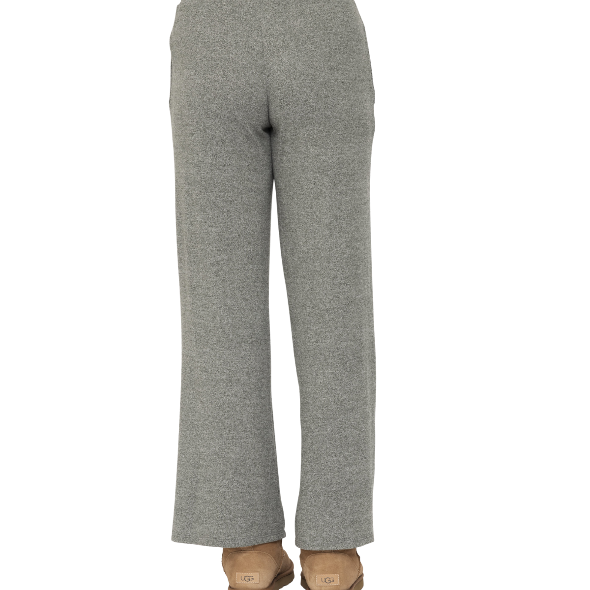 A person stands with their back to the camera against a white background, wearing Fashiongo Brushed Hacci Wide Leg Lounge Pants in gray with a drawstring waist and tan slippers.