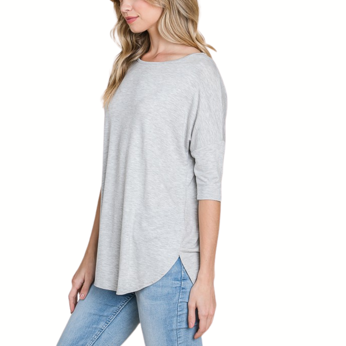 A woman wears a loose fit, light gray Basic Crew Neck T-Shirt by FASHION GO, made from soft rayon spandex, and light blue jeans, standing against a white background.