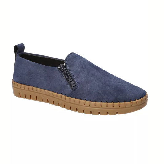 The EASY STREET Astoria Zip Up Flats in Navy feature a suede finish, side zipper, and tan rubber sole, offering women a stylish and comfortable slip-on flat for casual wear.