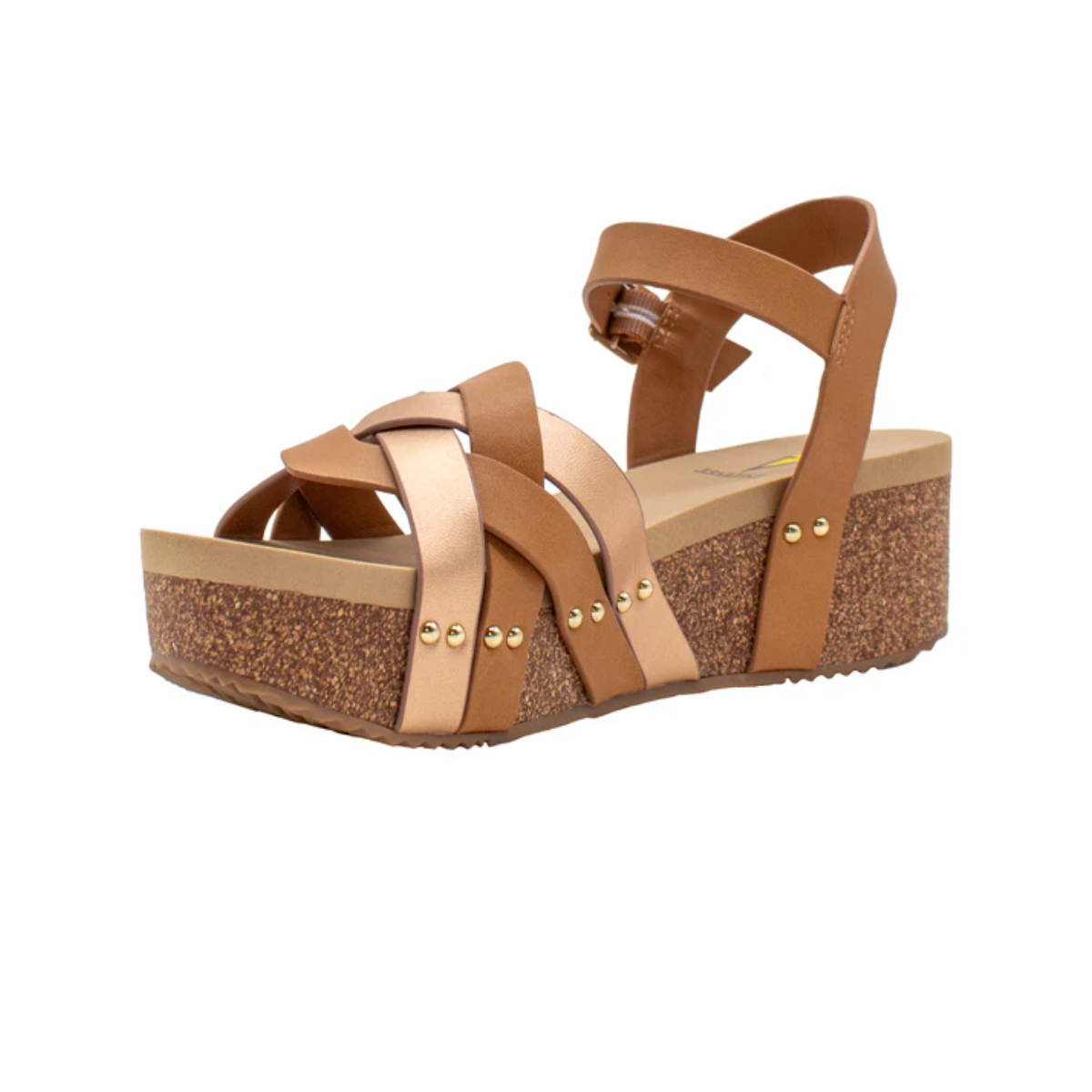 The Edna Wedge Sandal in Rose Gold - Tan Combo by Volatile features a brown platform wedge with crisscross straps, a faux leather upper, and an ankle buckle. It has a cork sole, EVA insole for comfort, and is adorned with gold stud accents for elegance.