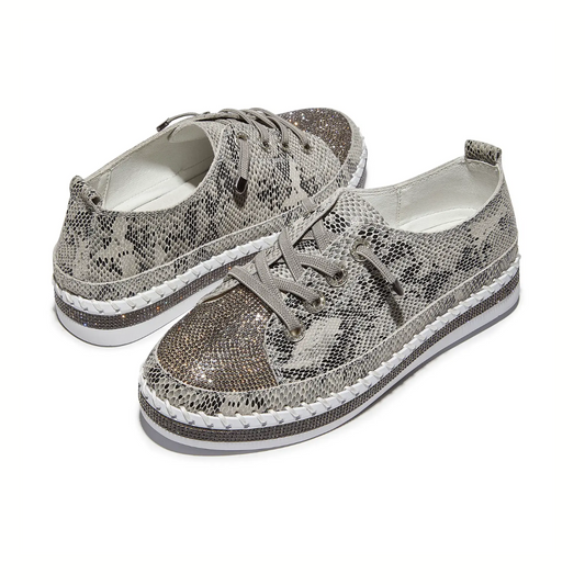 The Jodie Rhinestone Embellished Python Print Sneaker by BERNIE MEV features gray python print, lace-up design, cushioned insoles, white soles, and decorative stitching, shown against a white background.