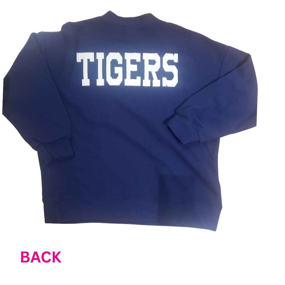 Show off your Auburn pride in the Tres Bien Paw Print TIGERS Cloudy Knit Top. This navy blue knit features "TIGERS" in large white letters on the back with a pink "BACK" detail, making it perfect for any fan on gameday.