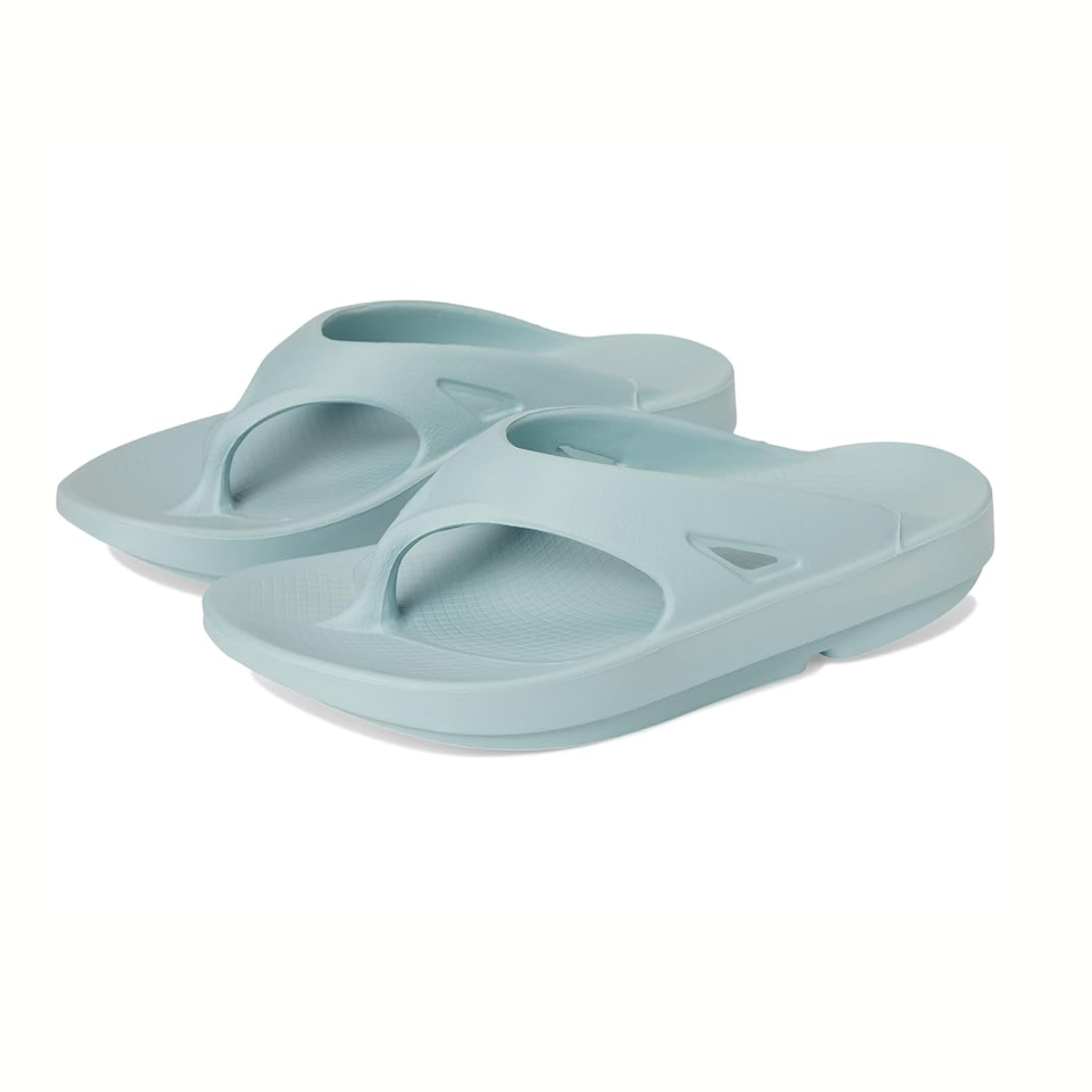 The OOfos OOriginal Flip Flop in Mist by OOFOS LLC features a light blue design with a toe loop and contoured footbed, enhanced by OOfoam™ technology for optimal support and cushioning. These foot recovery sandals are APMA approved for trusted quality.