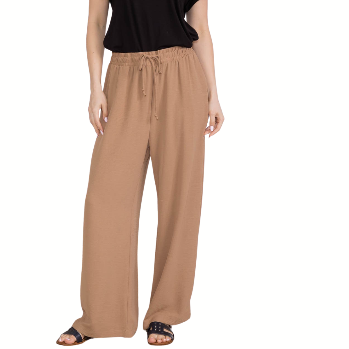 A person wearing FASHION GO Air Flow Fabric Drawstring Pants with Side Pockets in Mocha, a black short-sleeve top, and black sandals stands against a white background.
