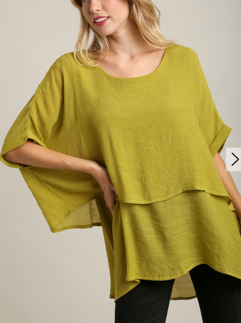 Woman posing in a Umgee Essential Top in Avocado with cuffed short sleeves and layered design.