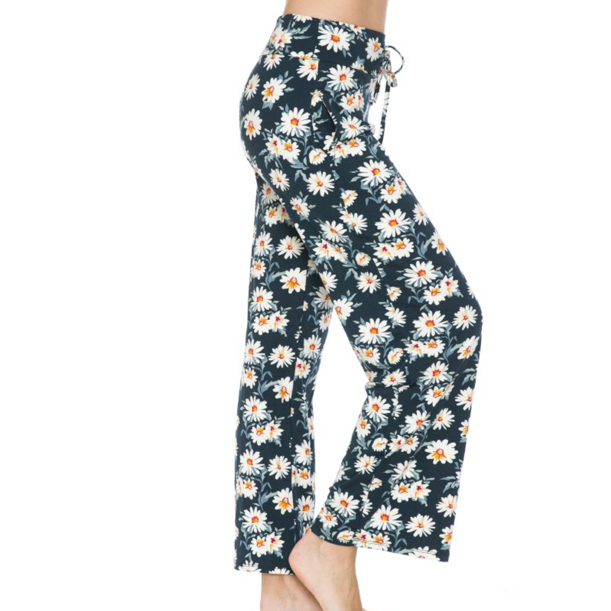 Person wearing FASHION GO Buttery Soft Pajama Pants with Drawstring in navy blue with a white and orange daisy print, featuring an elastic waistband and functional pockets.