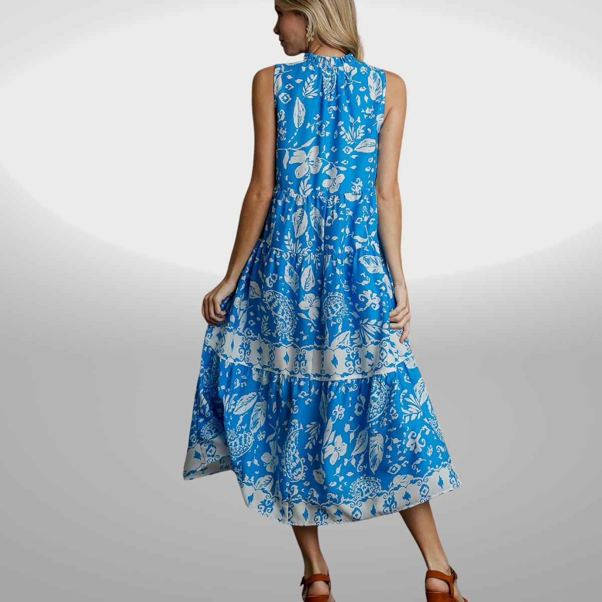 The back view of a woman wearing a blue Floral Sleeveless Midi Dress by FASHION GO.