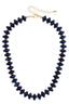 The Marseille Resin Beaded Necklace features adjustable round, dark blue resin beads alternating with small gold-tone spacers, finished with a gold-tone lobster clasp and extender chain.