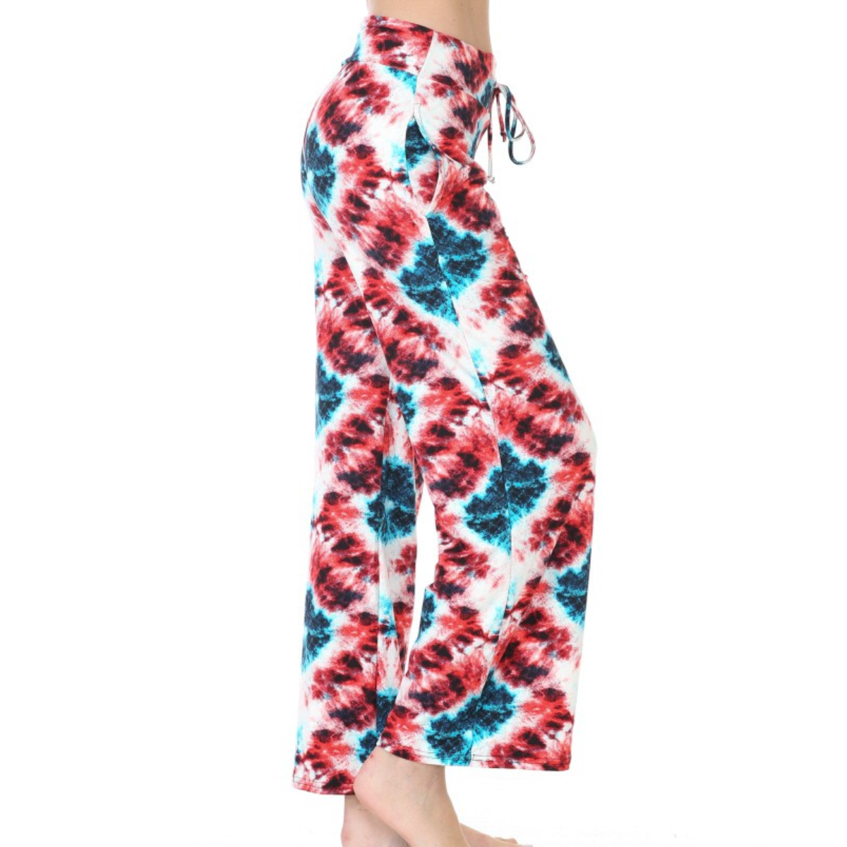 Person wearing FASHION GO Buttery Soft Pajama Pants with Drawstring with a red, blue, and white tie-dye pattern. The buttery soft fabric and elastic waistband ensure comfort, while functional pockets add practicality. Photo shows a side view from waist to feet.