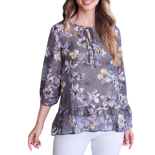A woman smiling at the camera, wearing a FASHION GO Floral Ruffle Hem Sheer Top.