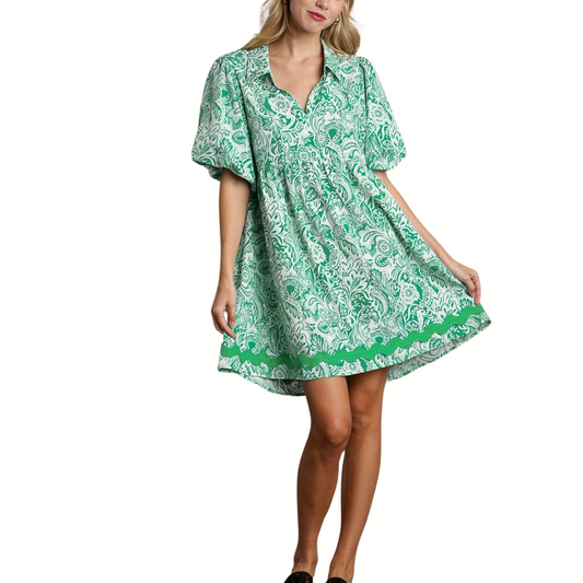 Woman in a green and white zig-zag patterned Balloon Sleeve Dress with Ric Rac Trim in Green by FASHION GO, standing against a white background.