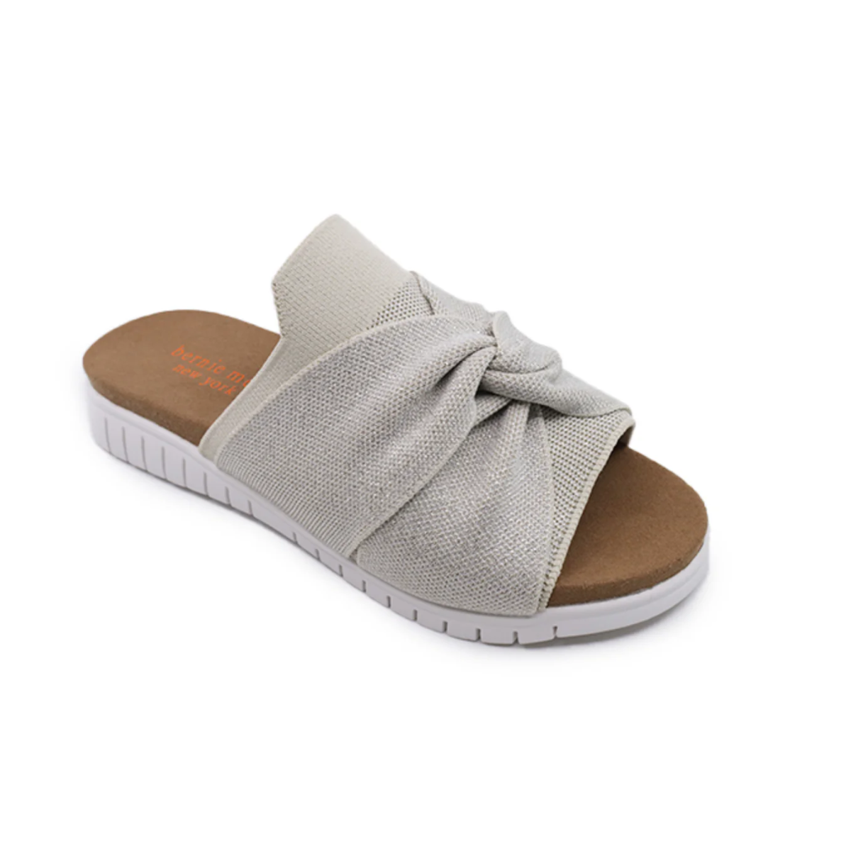 The Twist Sandal by BERNIE MEV is a light gray slip-on with flexible uppers, a textured knot design, brown footbed, and white rubber sole. Available in Euro sizes and shown on a white background.