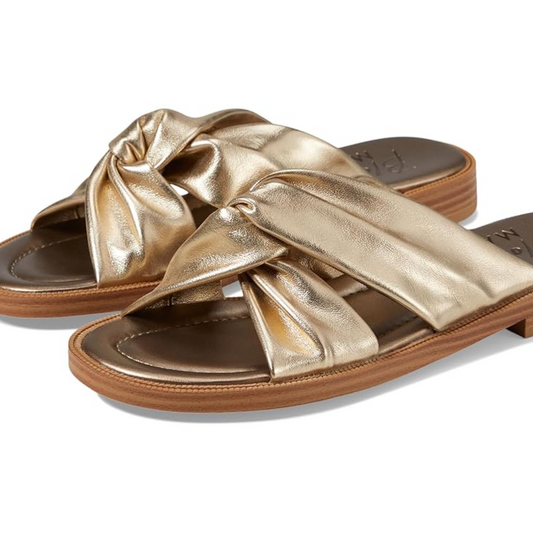 A pair of metallic gold Adios sandals by Blowfish with knotted bow details and a BLOOM foam footbed.