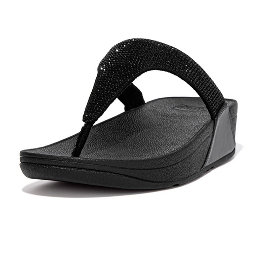 The Lulu Crystal Embellished Toe Post Flip Flop in Black by FIT FLOPS, presented from a side angle, showcases textured straps and footbed. It features FITFLOP's signature Microwobbleboard™ midsoles for enhanced comfort and style, adorned with subtle micro-crystals.