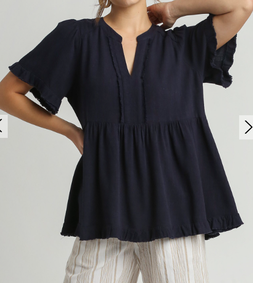 A model wearing a Umgee navy linen V-Neck top with ruffles.