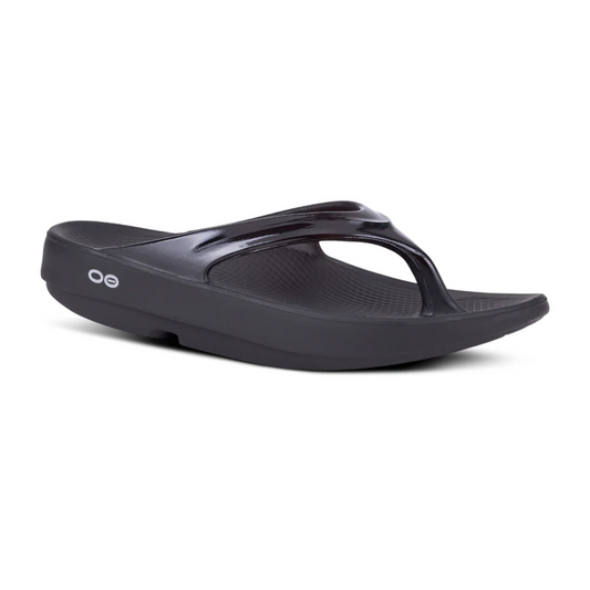 A black Oolala Thong Flip Flop by OOFOS LLC with a unique toe design and circular brand logo on the side, featuring an OOFoam footbed, isolated on a white background.