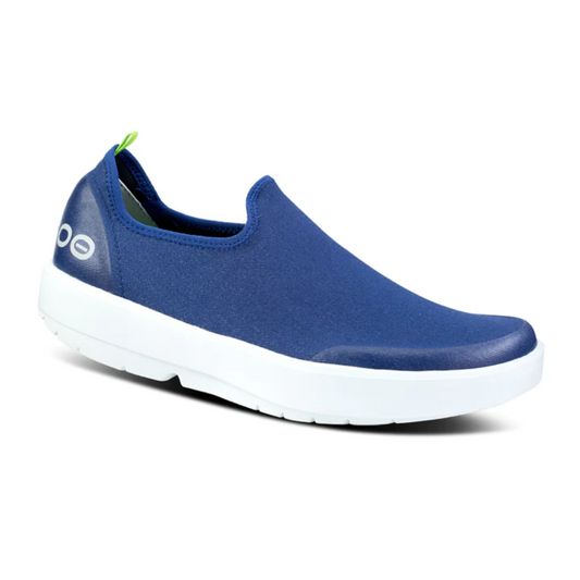 A single OOMG EeZee Low Canvas Shoe in Navy and White by Oofos with white sole, decorative eyes on the toe, and impact-absorbing arch support.