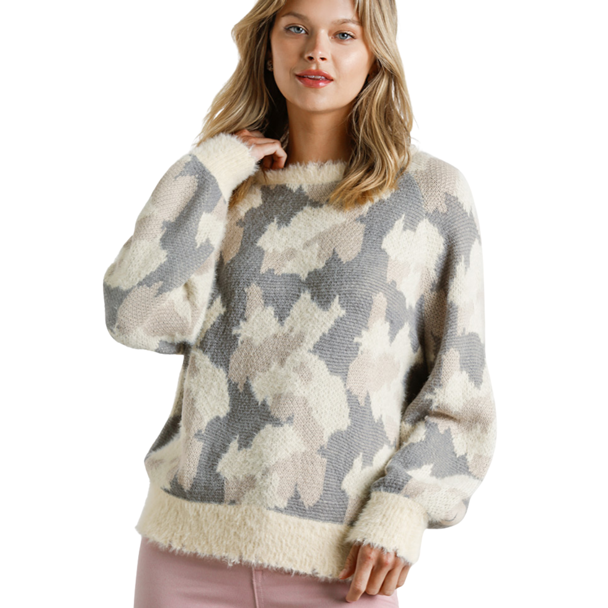A woman wears the Umgee Cream mix Print Sweater, featuring an abstract beige, gray, and cream pattern, paired with light pink pants, standing against a white background.