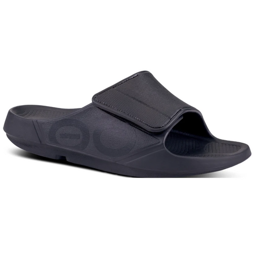 Black Sport Flex Matte Black slide sandal with adjustable upper strap on a white background by OOFOS LLC.