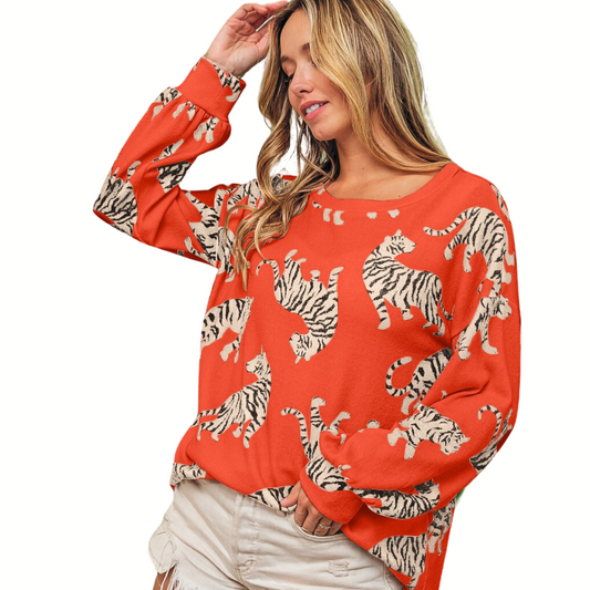 Woman wearing a Tiger Print Mire Brushed Knit Pull Over top in Orange from FASHION GO.