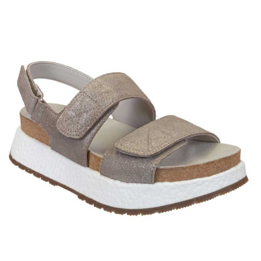 A single silver shimmer Wandering Sandal by Consolidated Shoe Co with a cork footbed.