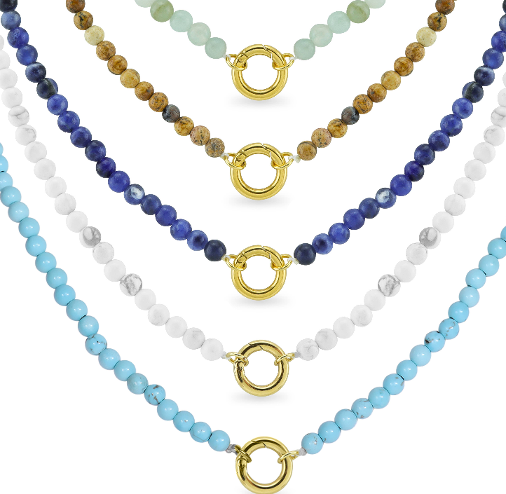 Five beaded necklaces are shown in a row, each with a different colored stone and a gold circular clasp at the center. The bead colors are green, brown, dark blue, white, and light blue.
